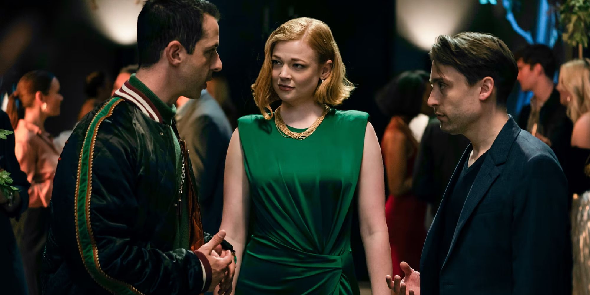 Kendall (played by Jeremy Strong), Shiv (played by Sarah Snook), and Roman (played by Kieran Culkin) stand and talk on Succession.