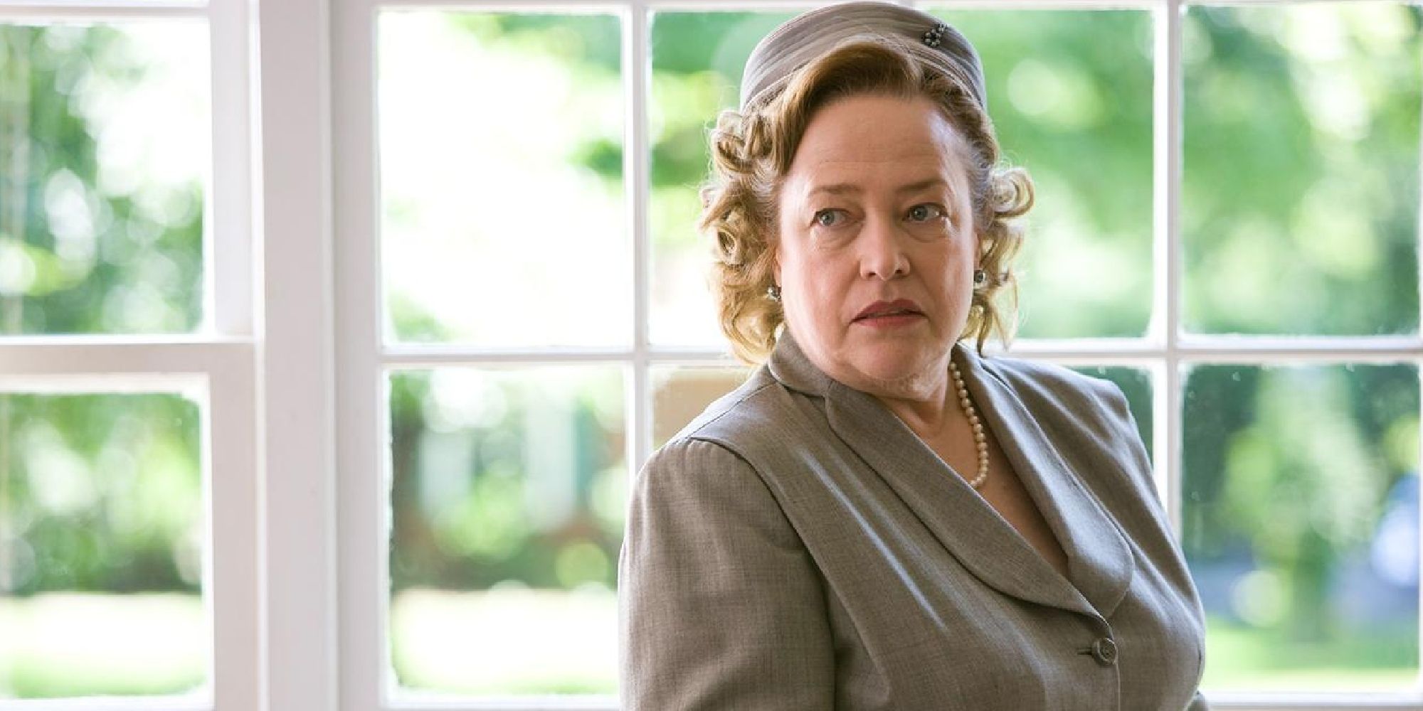 Kathy Bates as Helen Givings standing beside a window in Revolutionary Road