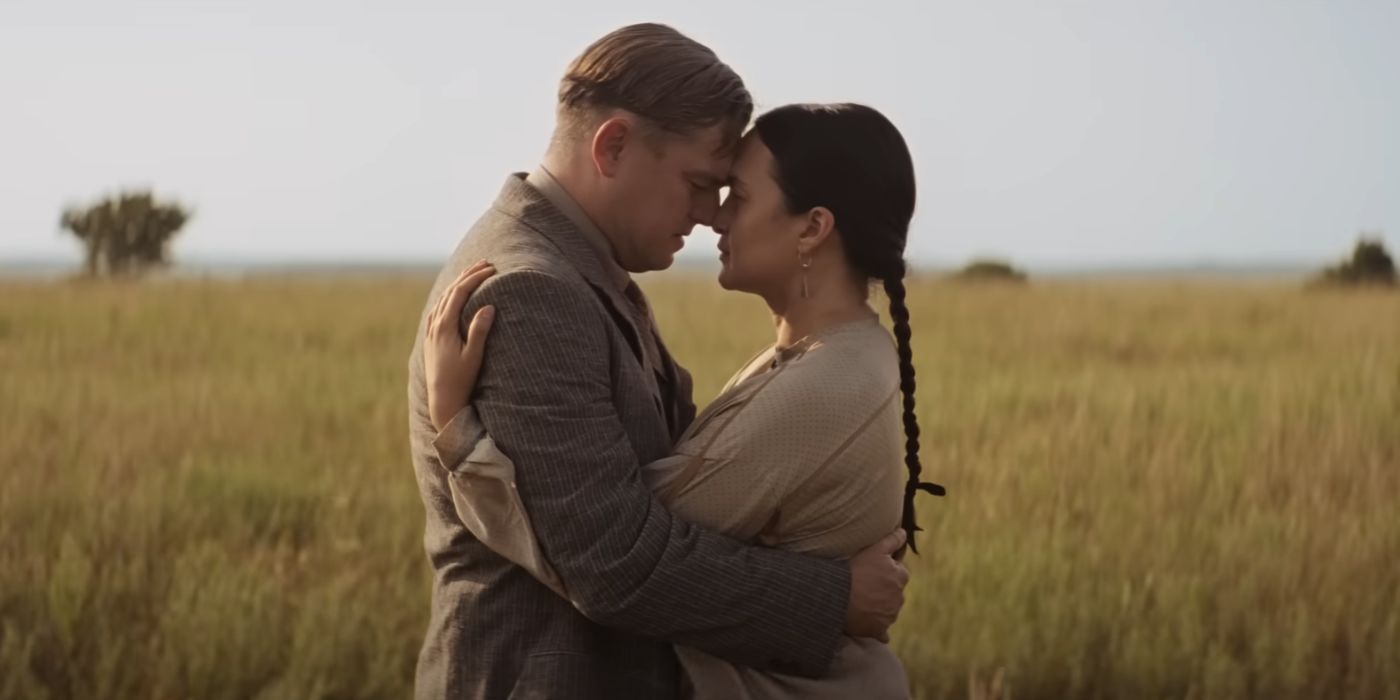 Leonardo DiCaprio and Lily Gladstone embracing in a field in Killers of the Flower Moon