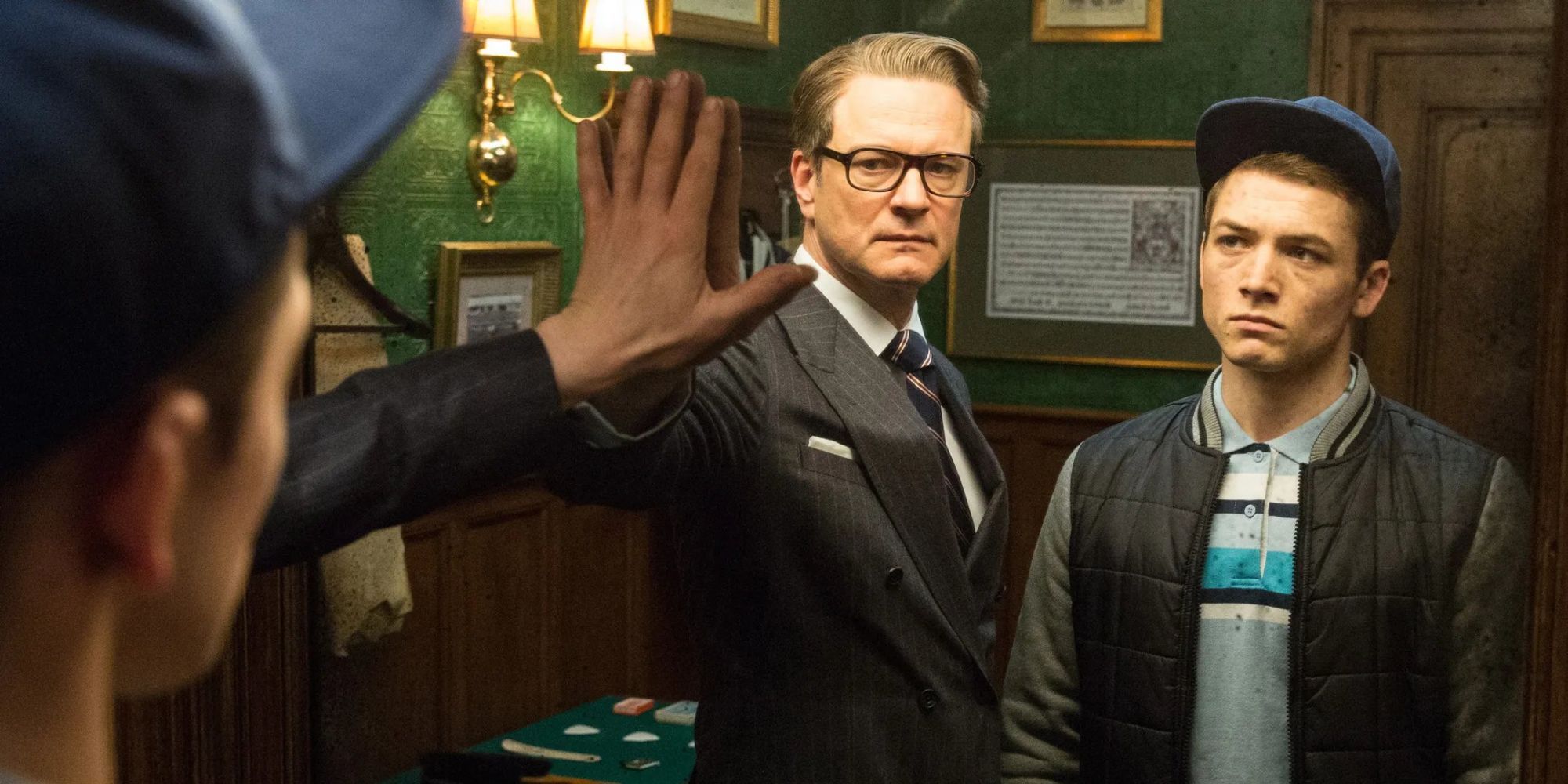 Colin Firth as Harry and Taron Egerton as Eggsy in front of a mirror in Kingsman: The Secret Service