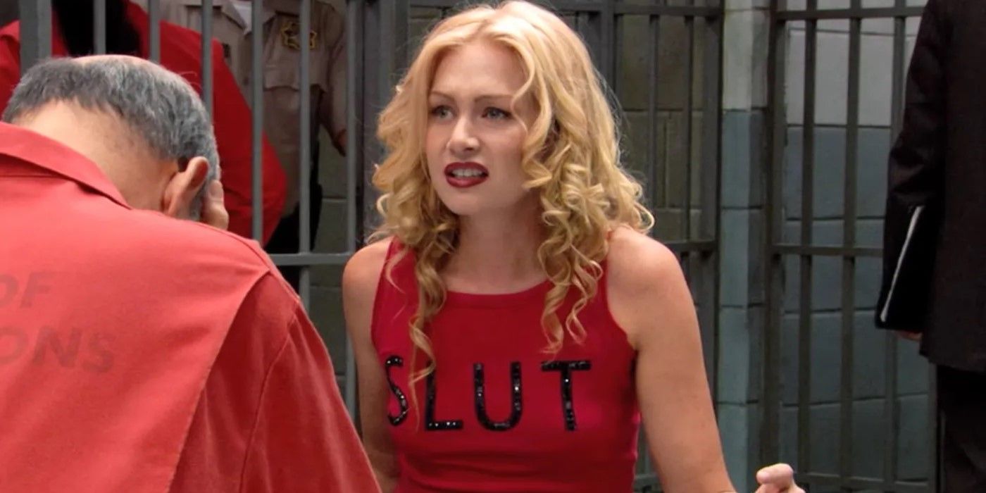 Still from 'Arrested Development': Lindsay Fünke (Portia de Rossi) sits in the prison greeting area looking confused, wearing a red t-shirt with 'SLUT' on it.