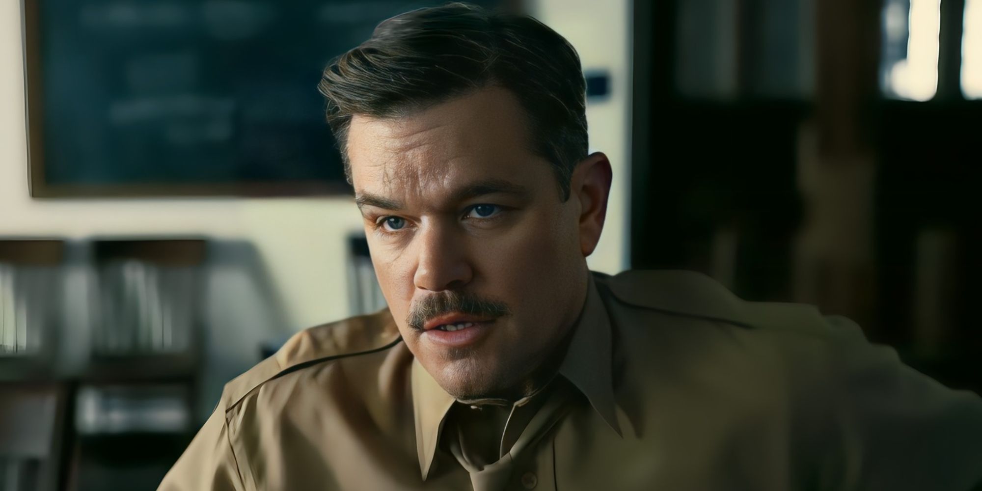 Matt Damon as Leslie Groves talking to someone off-camera in the film Oppenheimer