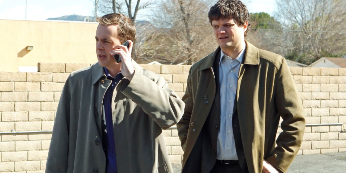Matt Jones stands next to Sean Murray while on the phone in NCIS