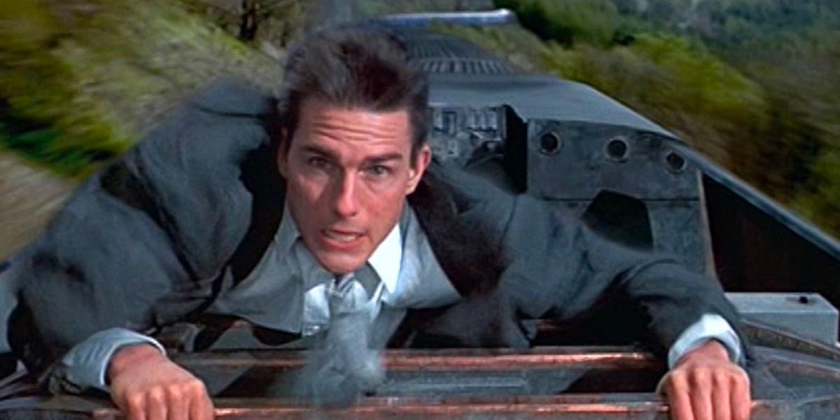 Ethan Hunt (Tom Cruise) climbs on top of a speeding train.