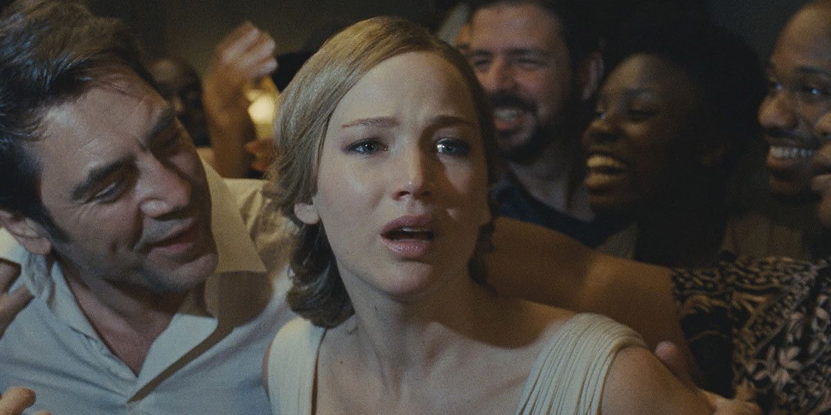 Still from "Mother!": Jennifer Lawrence looks worried, surrounded by smiling people including Javier Bardem.
