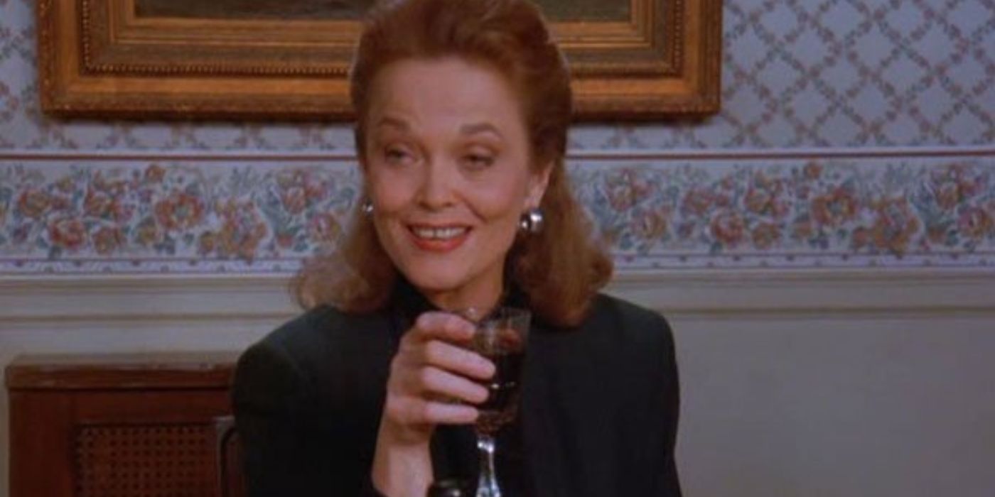 Mme Ross riant en tenant un verre de vin à Seinfeld