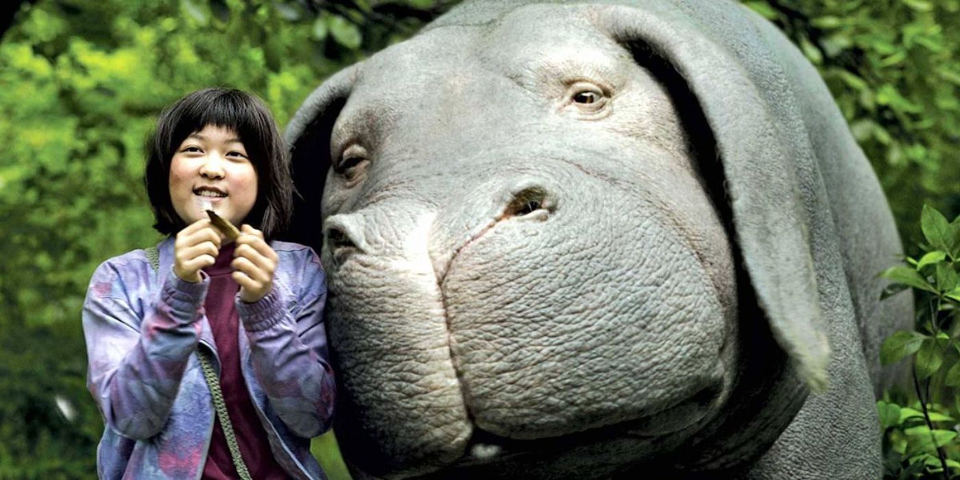 A young girl next to Okja the super pig in 'Okja'