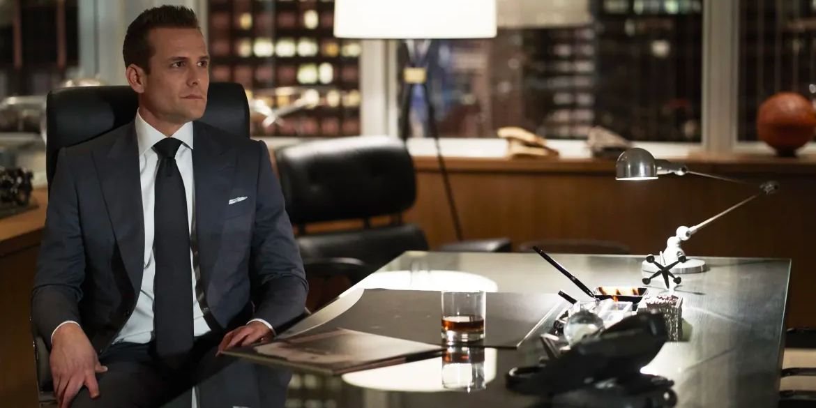 Harvey Spectre (Gabriel Macht) sits behind his desk with a glass of whiskey.