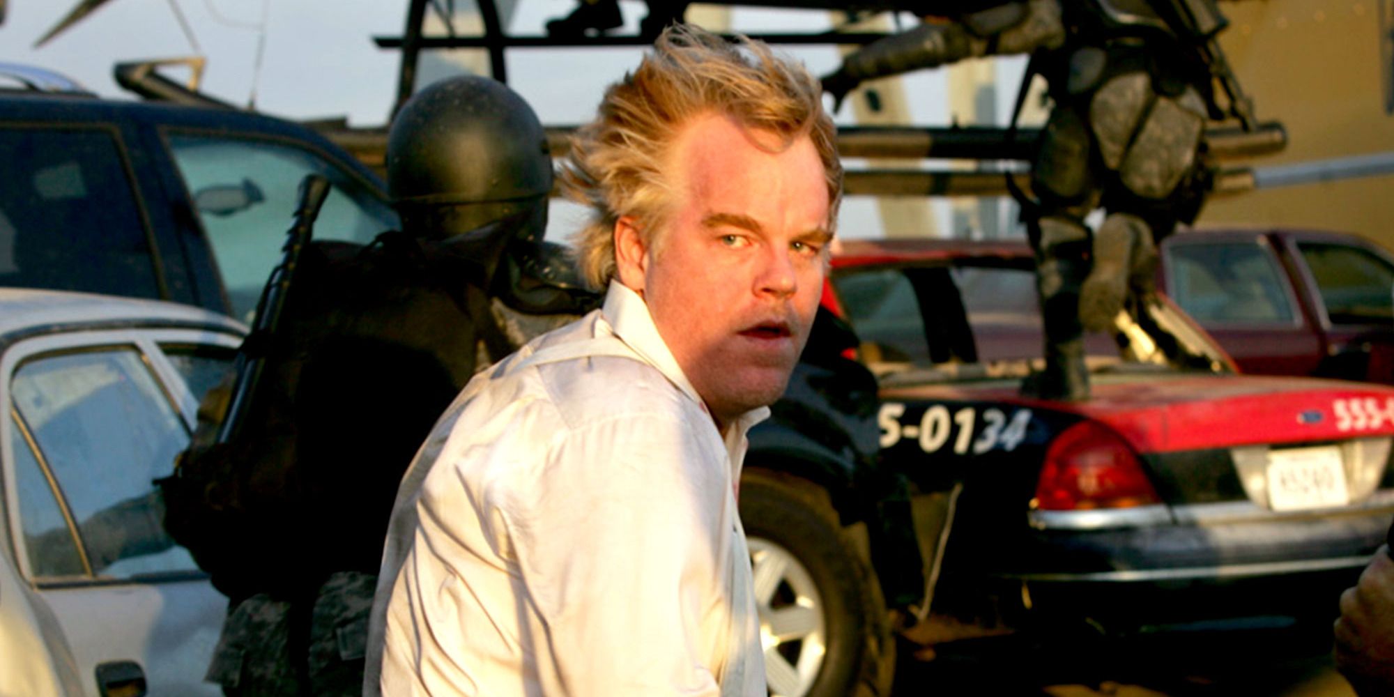 Philip Seymour Hoffman in 'Mission Impossible III', being escorted by troopers to a helicopter