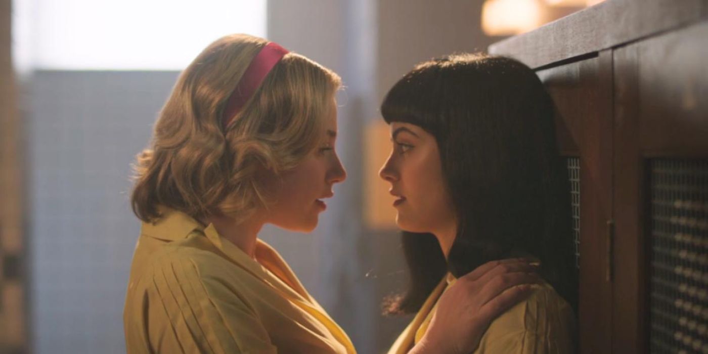 Betty (Lili Reinhart) and Veronica (Camila Mendes) up against the lockers leaning in for a kiss in Riverdale Season 7