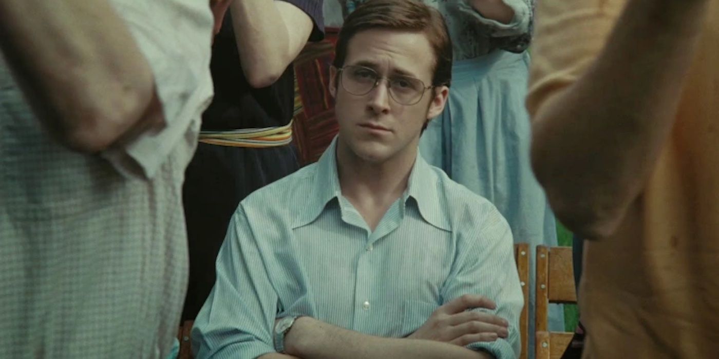 Ryan Gosling as David Marks, sitting glumly with his arms crossed while people around him stand and clap in All Good Things 