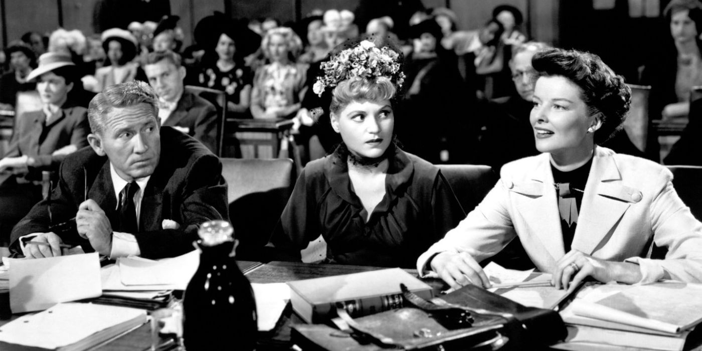 Spencer Tracy sitting with Judy Holliday and Katharine Hepburn in a court room in Adam's Rib (1949)