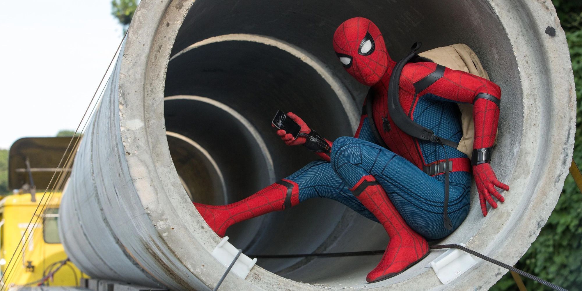 Tom Holland as Peter Parker/Spider-Man wearing a backpack and hiding in a cement pipe In Spider Man: Homecoming