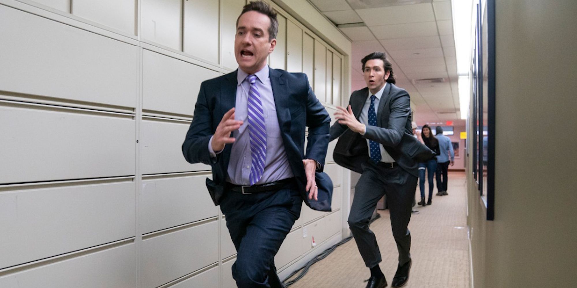 Cast members run down an office hallway in Succession episode Safe Room.
