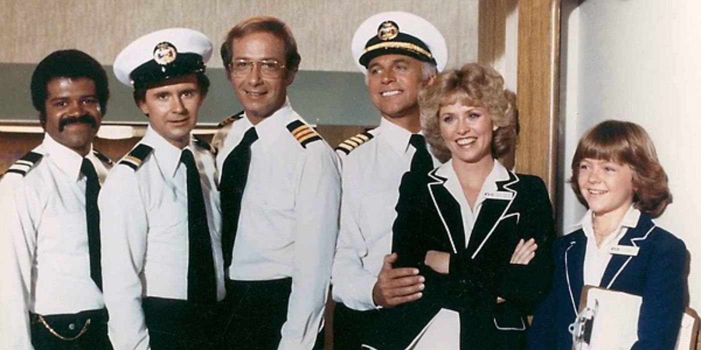 The cast of The Love Boat in nautical uniforms smiling in a posed image.