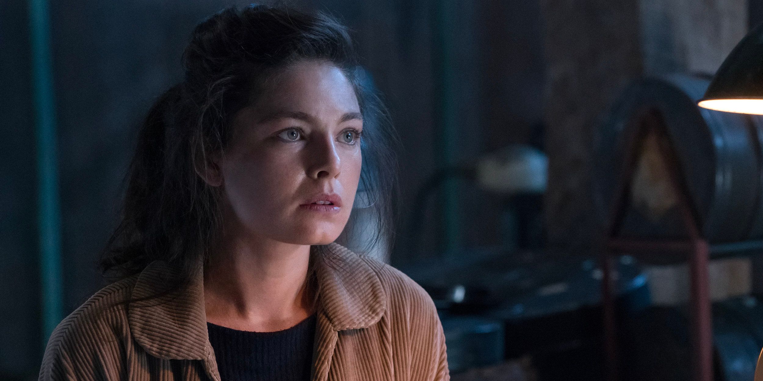 A girl sits in a darkened room in 'The Man in the High Castle'