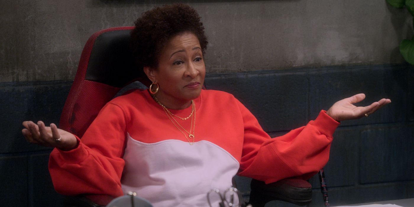 Wanda Sykes as Lucretia sitting with her opens spread in The Upshaws