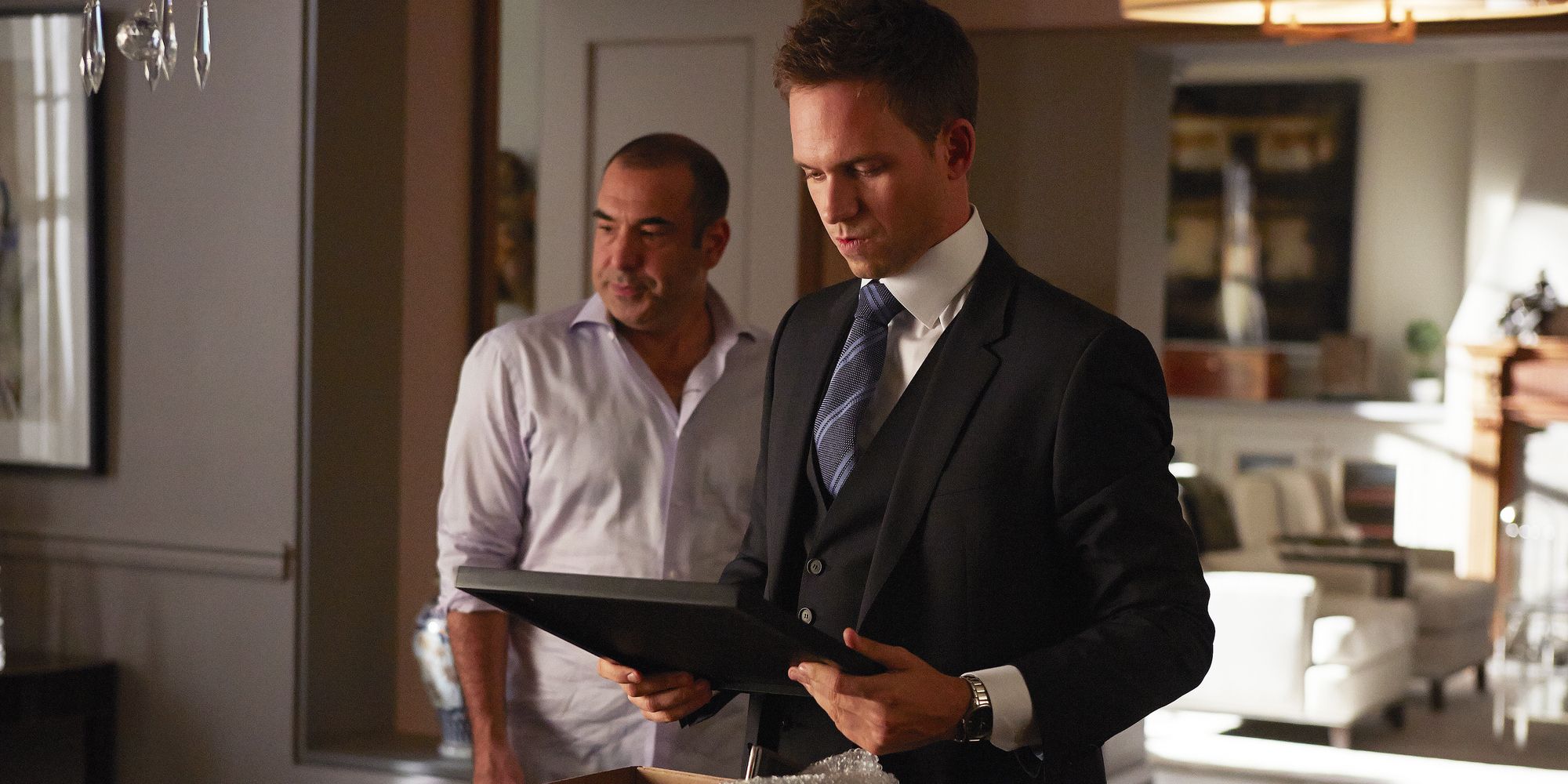 Mike Ross (Patrick J. Adams) looks over Louis' (Rick Hoffman) possessions as he helps his former colleague.