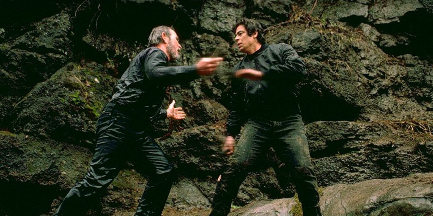 Tommy Lee Jones and Benicio Del Toro fighting by a mountain in The Hunted