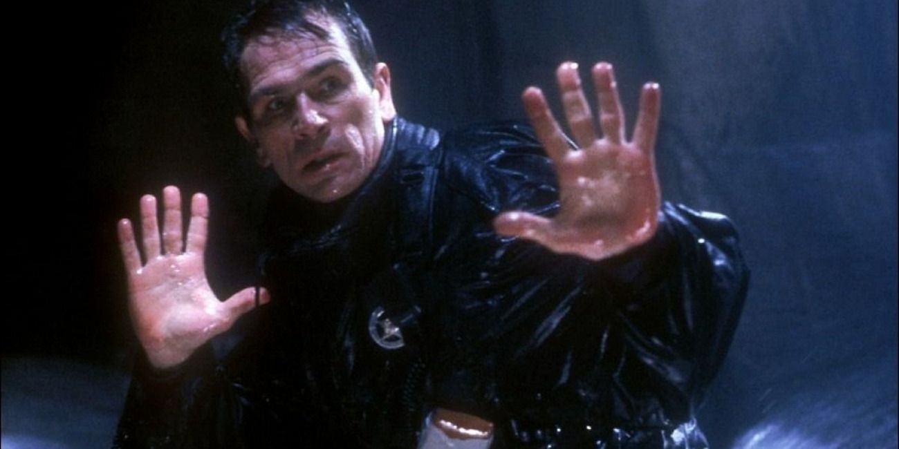 a cop in &lsquo;The Fugitive&rsquo;, wet and raising his hands in defeat