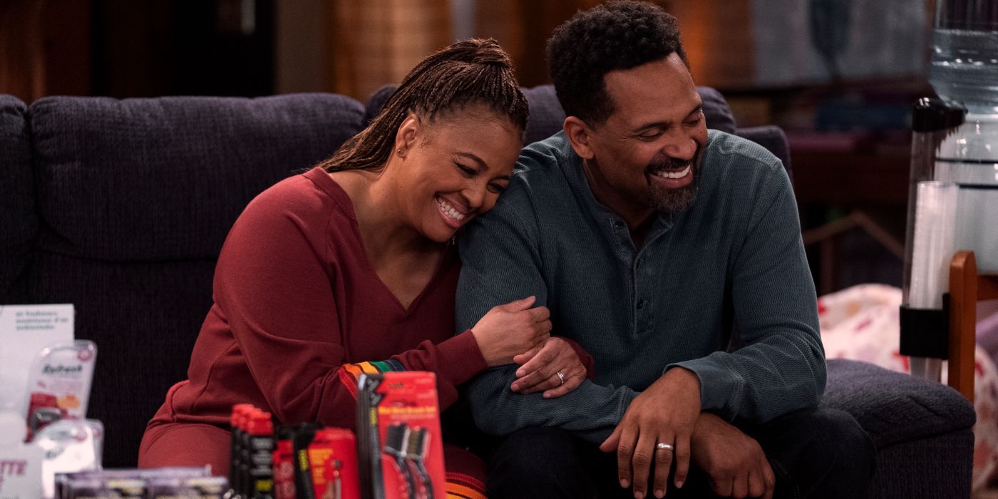 Kim Fields and Mike Epps sitting on the couch laughing in The Upshaws