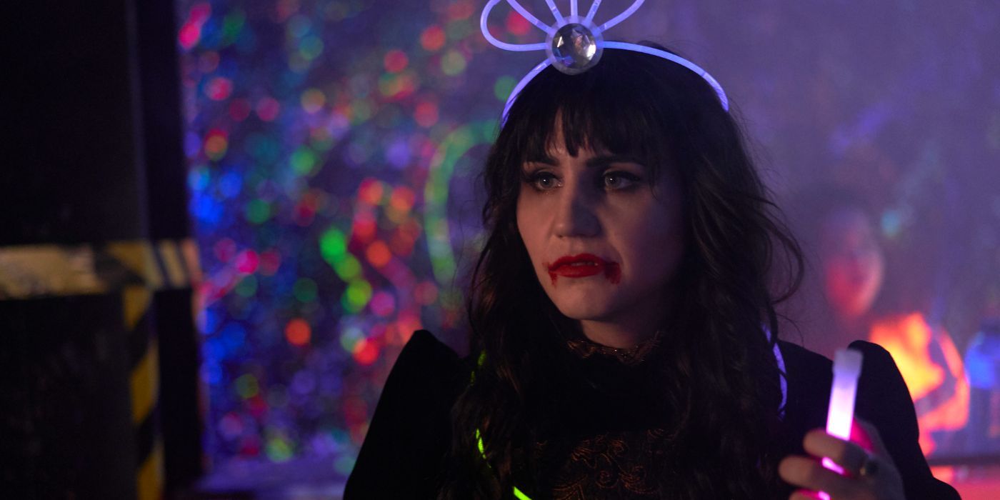 Nadja of Antipaxos, played by Natasia Demetriou, at a party wearing a glow stick crown in 'What We Do in the Shadows.'