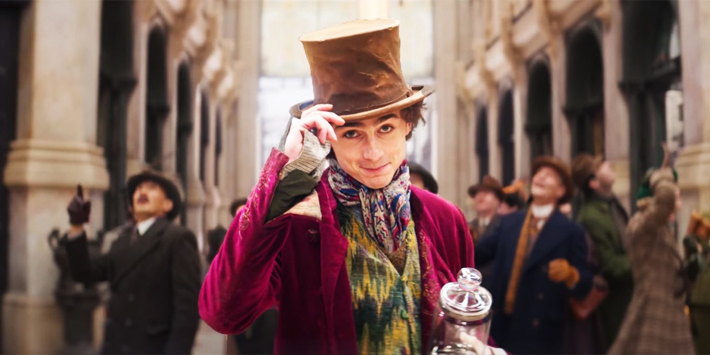 Timothée Chalamet como el joven Willy Wonka inclinando su sombrero en la concurrida estación de tren de Wonka.