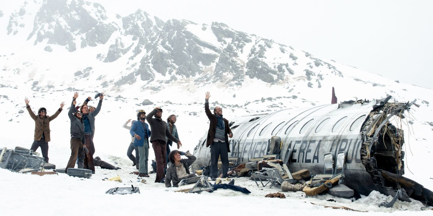 A group of people signal for help in a snowy landscape in 'Sociedad de la Nieve'