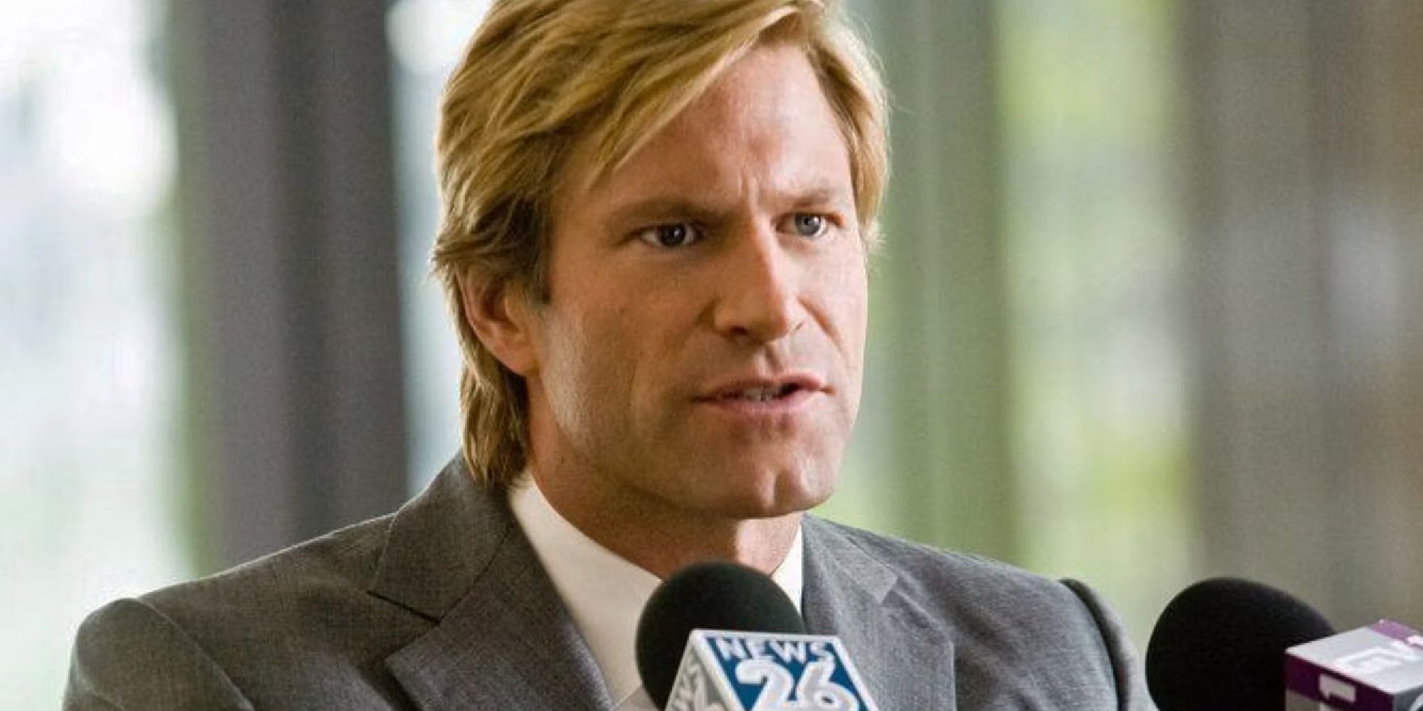 Aaron Eckhart as Harvey Dent addressing reporters in The Dark Knight