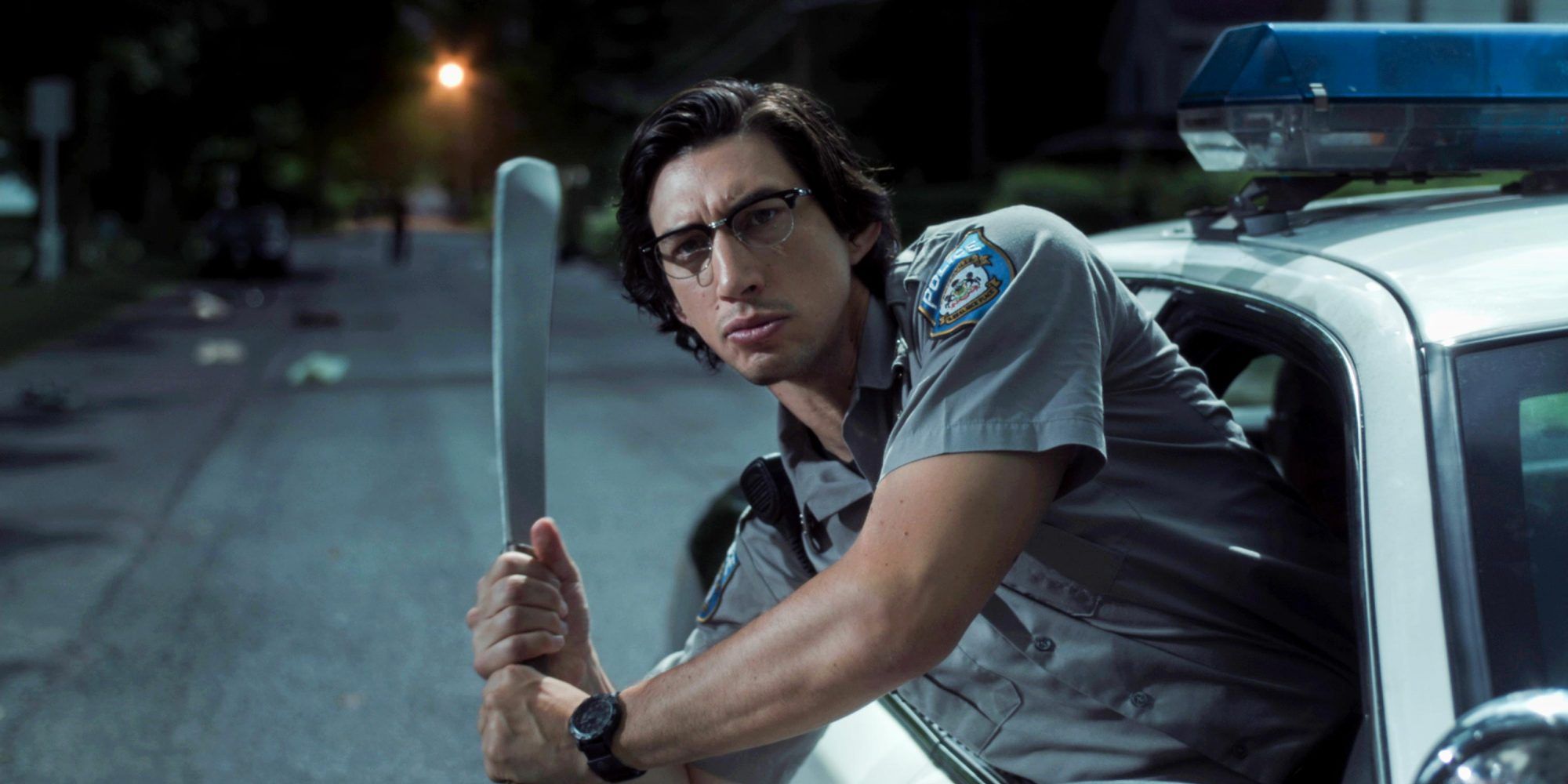 Adam Driver in hanging outside a car window holding a baseball bat in 'The Dead Don't Die'