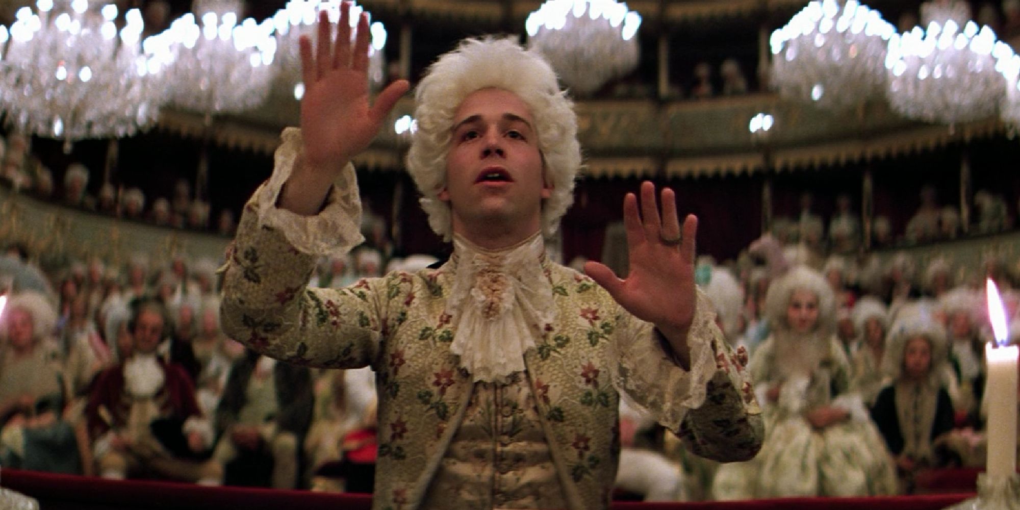 Tom Hulce as Mozart conducting while an audience sits behind in Amadeus