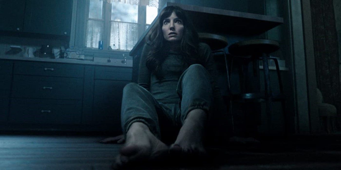 Annabelle Wallis as Madison Mitchell sits in a kitchen barefoot and looks scared in Malignant.