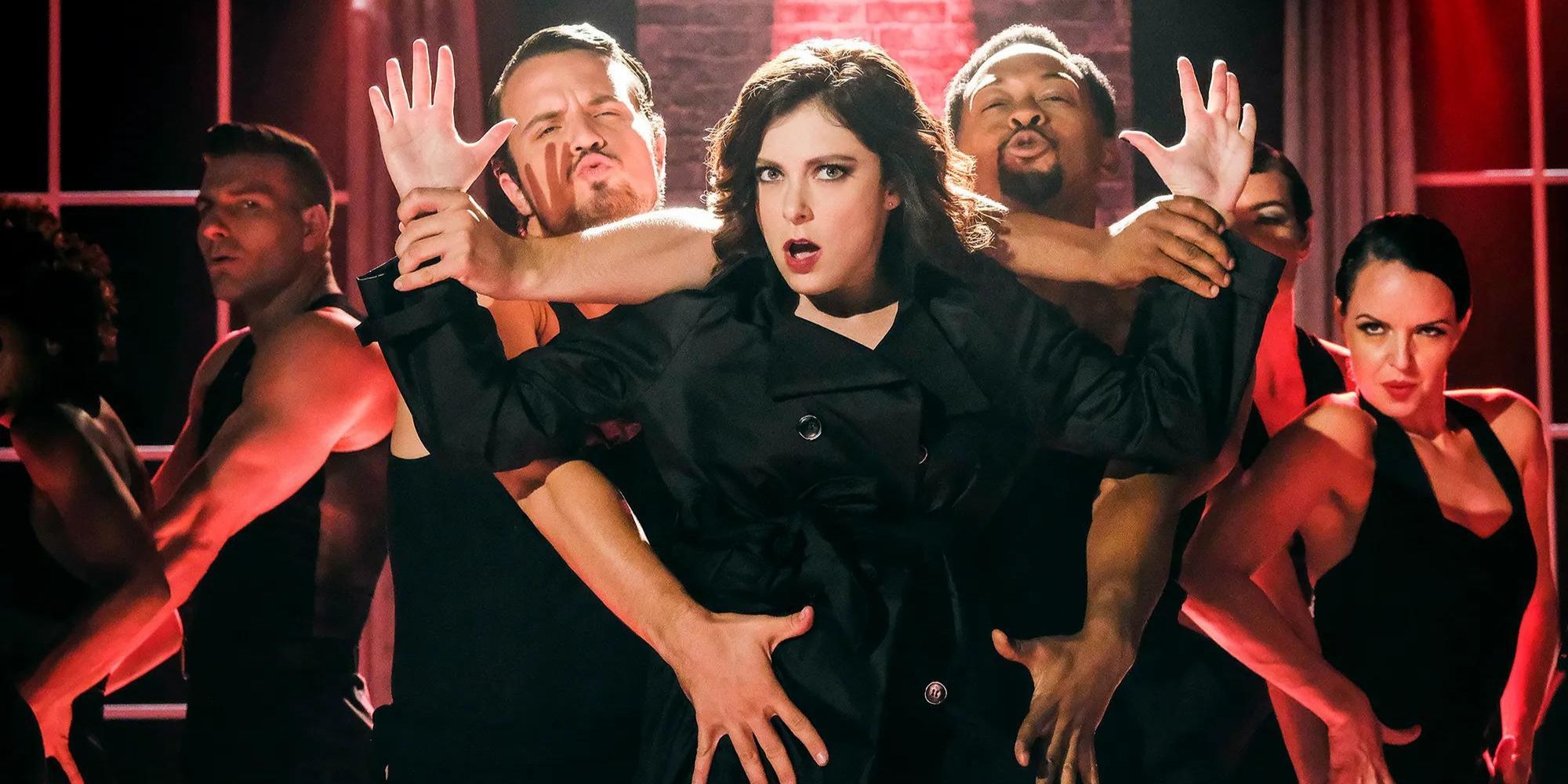 Rebecca from Crazy Ex-Girlfriend dancing with other dancers close around her all in black costumes.