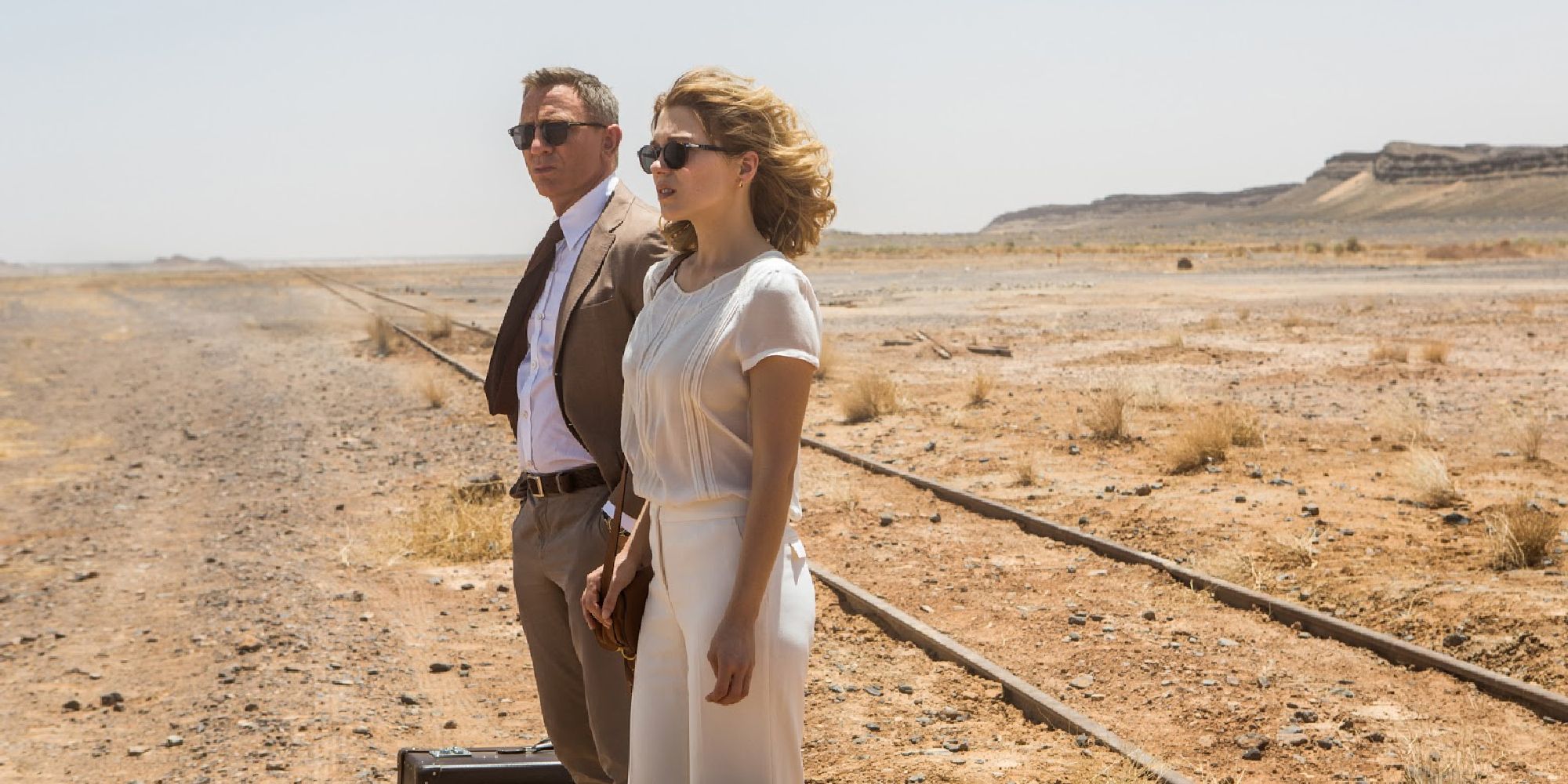 Daniel Craig (James Bond) and Lea Seydoux (Madeleine Swann) standing by train tracks in 'Spectre'