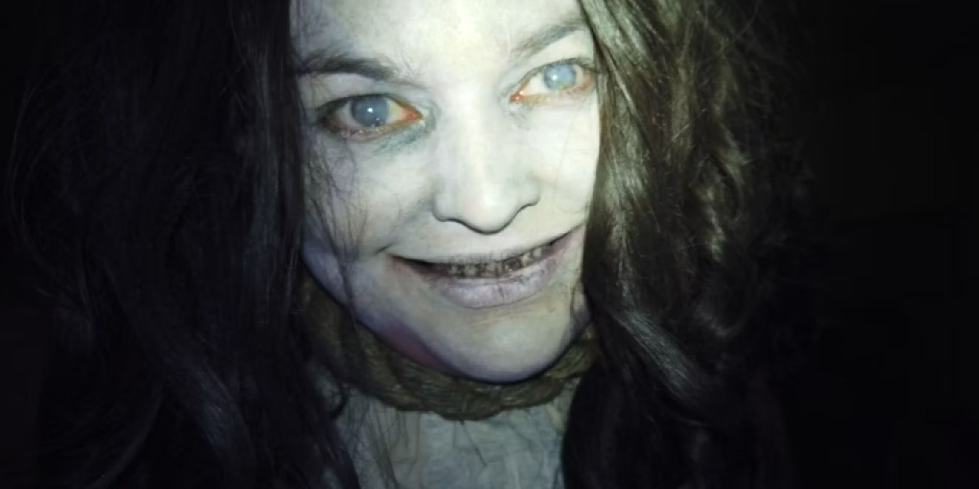 A zombie-looking woman smiling directly for the camera in Deadstream