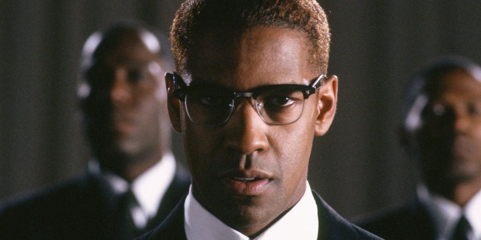 Denzel Washington in 'Malcolm X', looking deeply at the camera with two men behind him