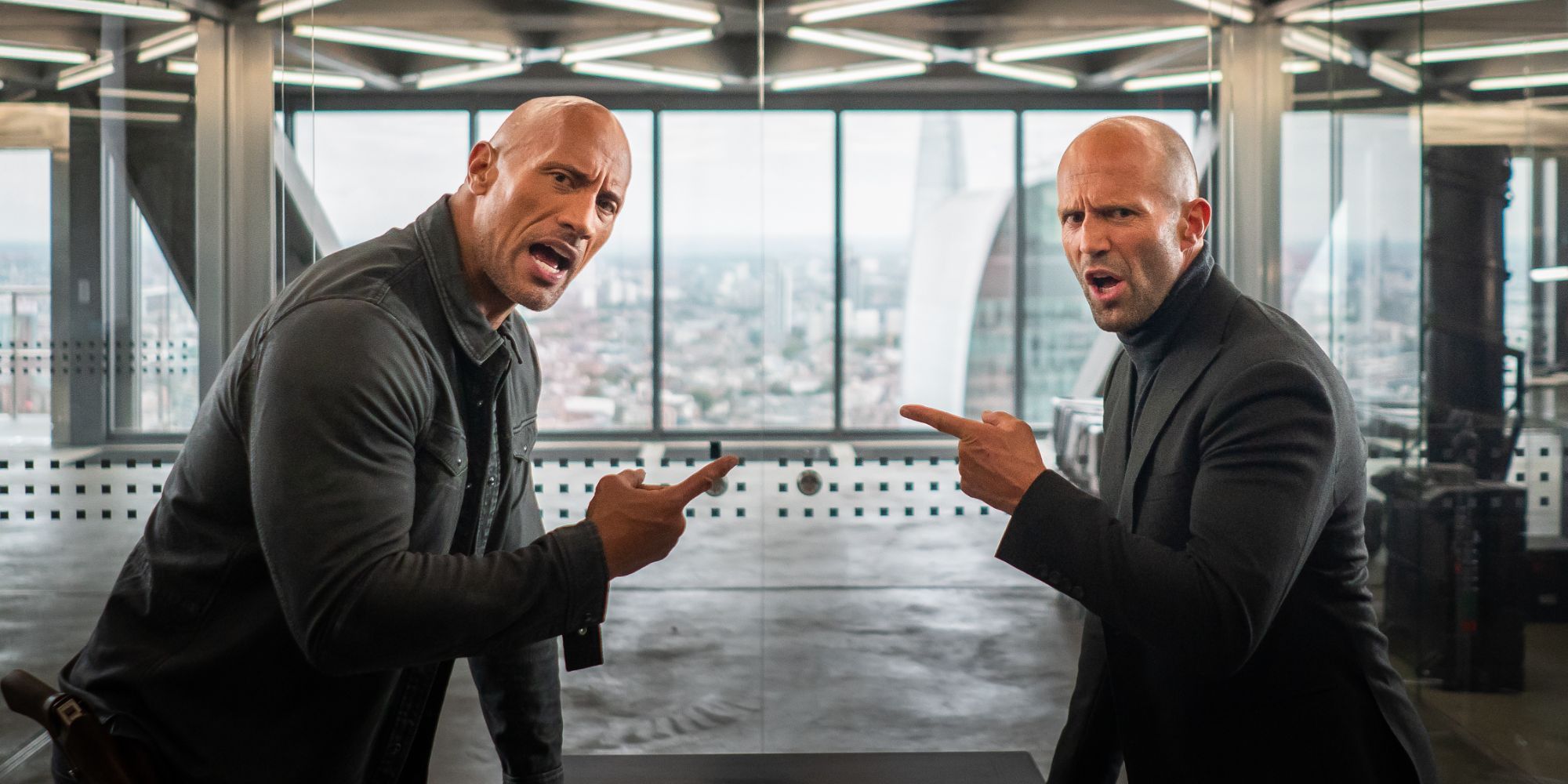 Hobbs and Shaw pointing at each other while looking at the camera with annoyed expressions in Fast & Furious Presents- Hobbs & Shaw