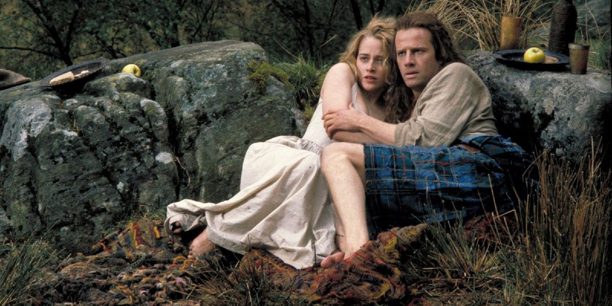 Roxanne Hart and Christopher Lambert on the ground embracing in 1986's 'Highlander'