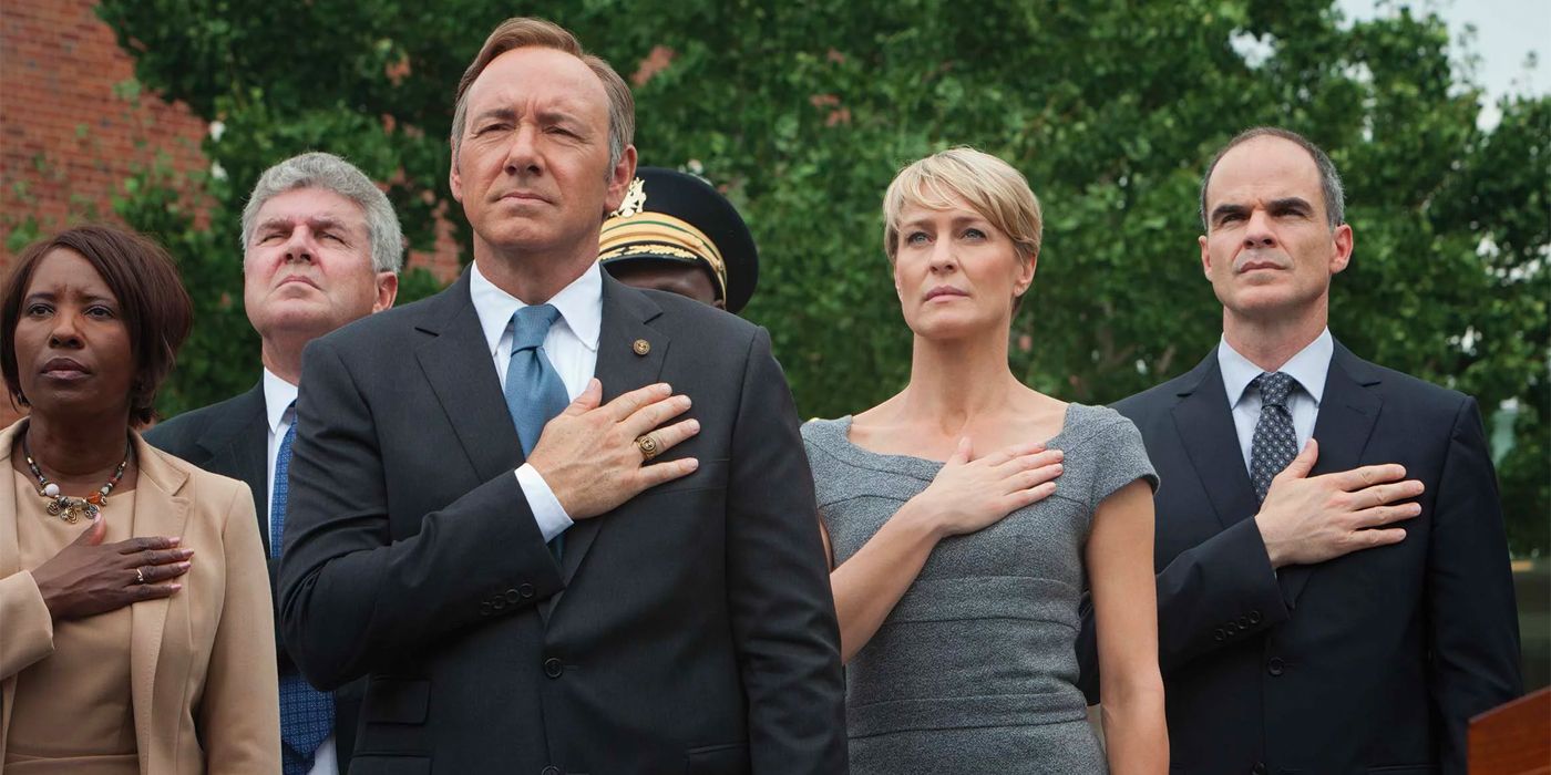Frank (Kevin Spacey), Claire (Robin Wright), and Doug (Michael Kelly) holding their hands over their hearts on House of Cards