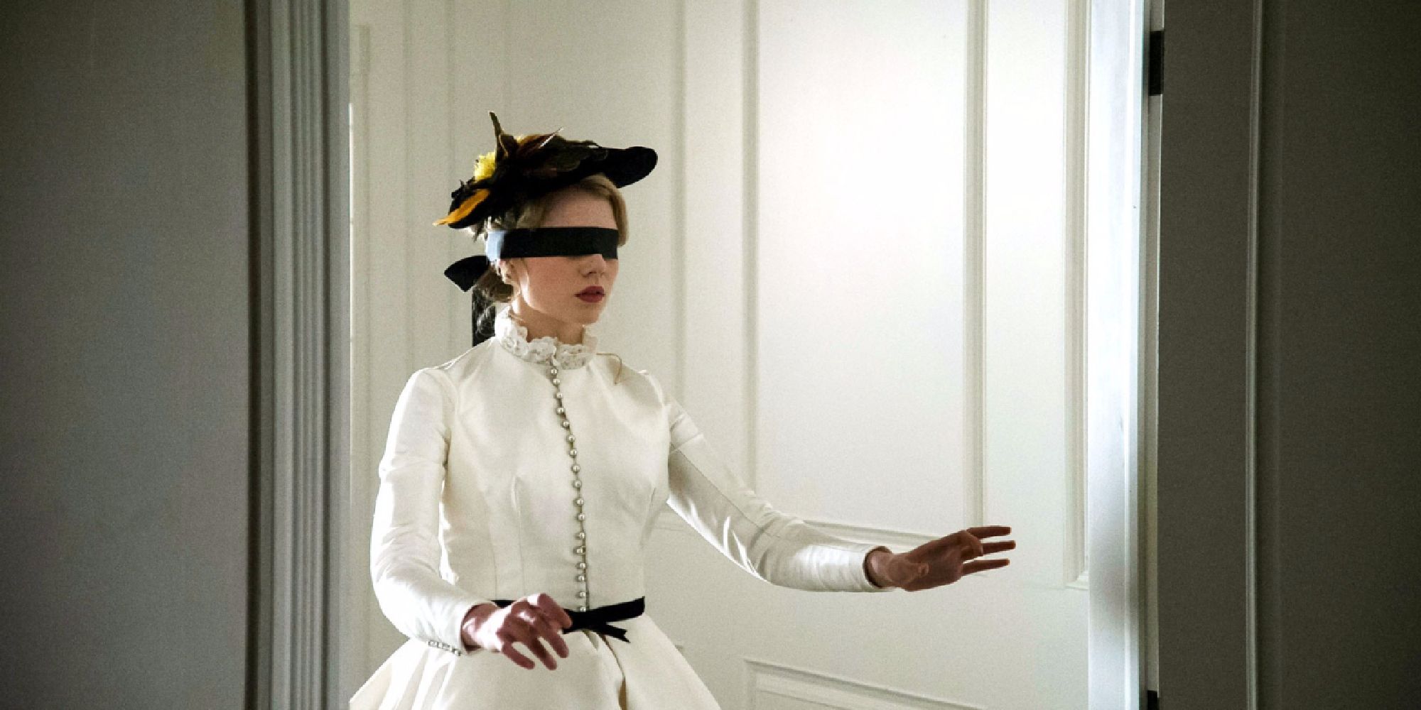 Polly Parsons (Lucy Boynton) is blindfolded and walking through a house in I Am the Pretty Thing That Lives in the House