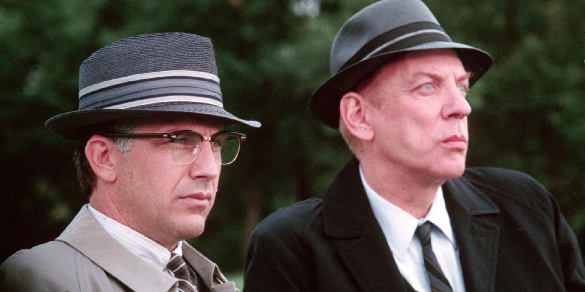 Kevin Costner as Jim Garrison and Donald Sutherland as Mr. X looking in the same direction in the film JFK