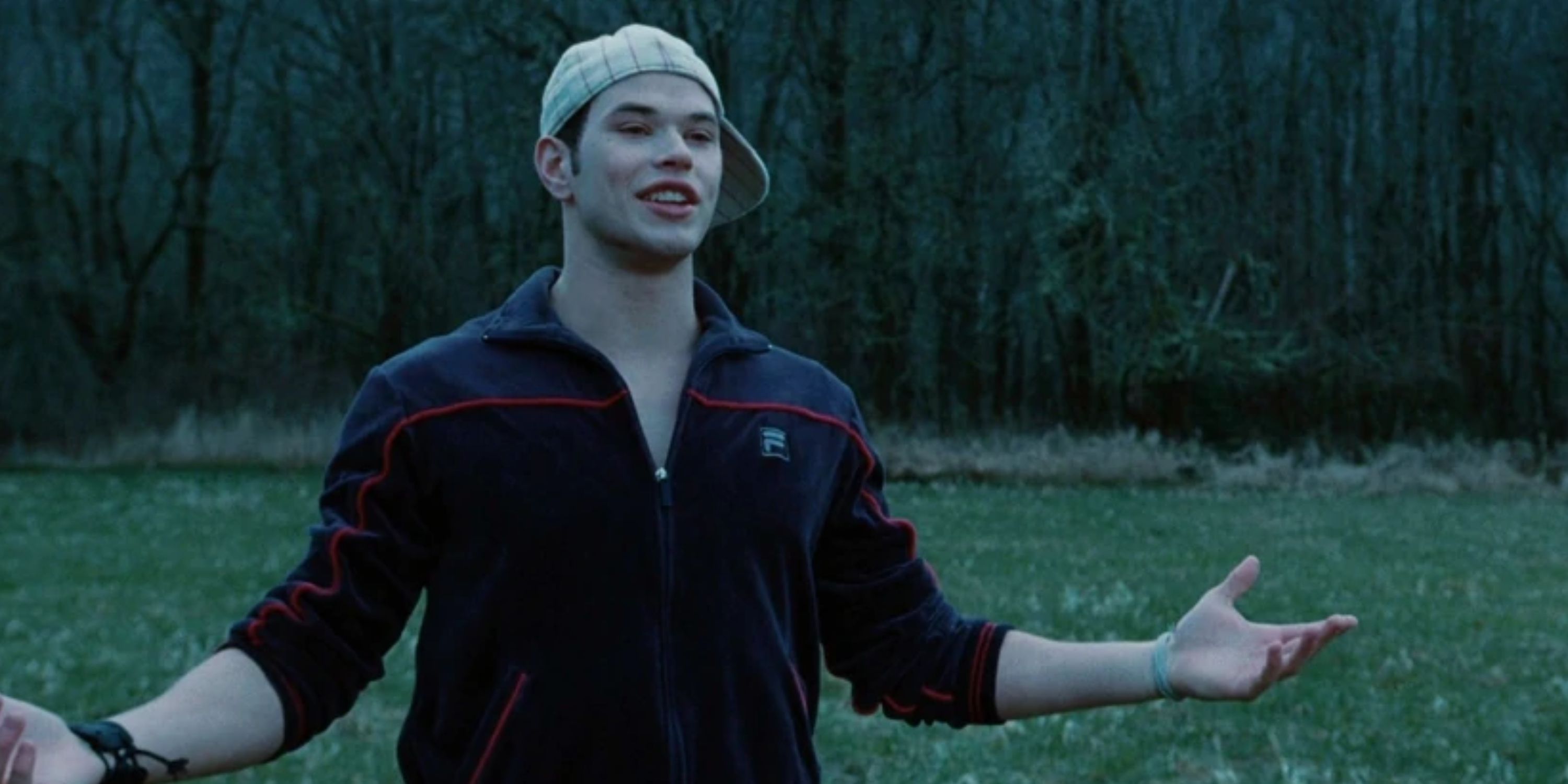 Emmett Cullen in 'Twilight', wearing a backwards baseball cap in a field.