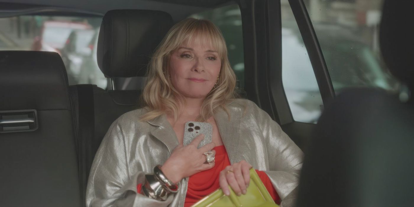 Kim Cattrall as Samantha Jones in the back of a car holding a phone to her heart in And Just Like That Season 2 Finale