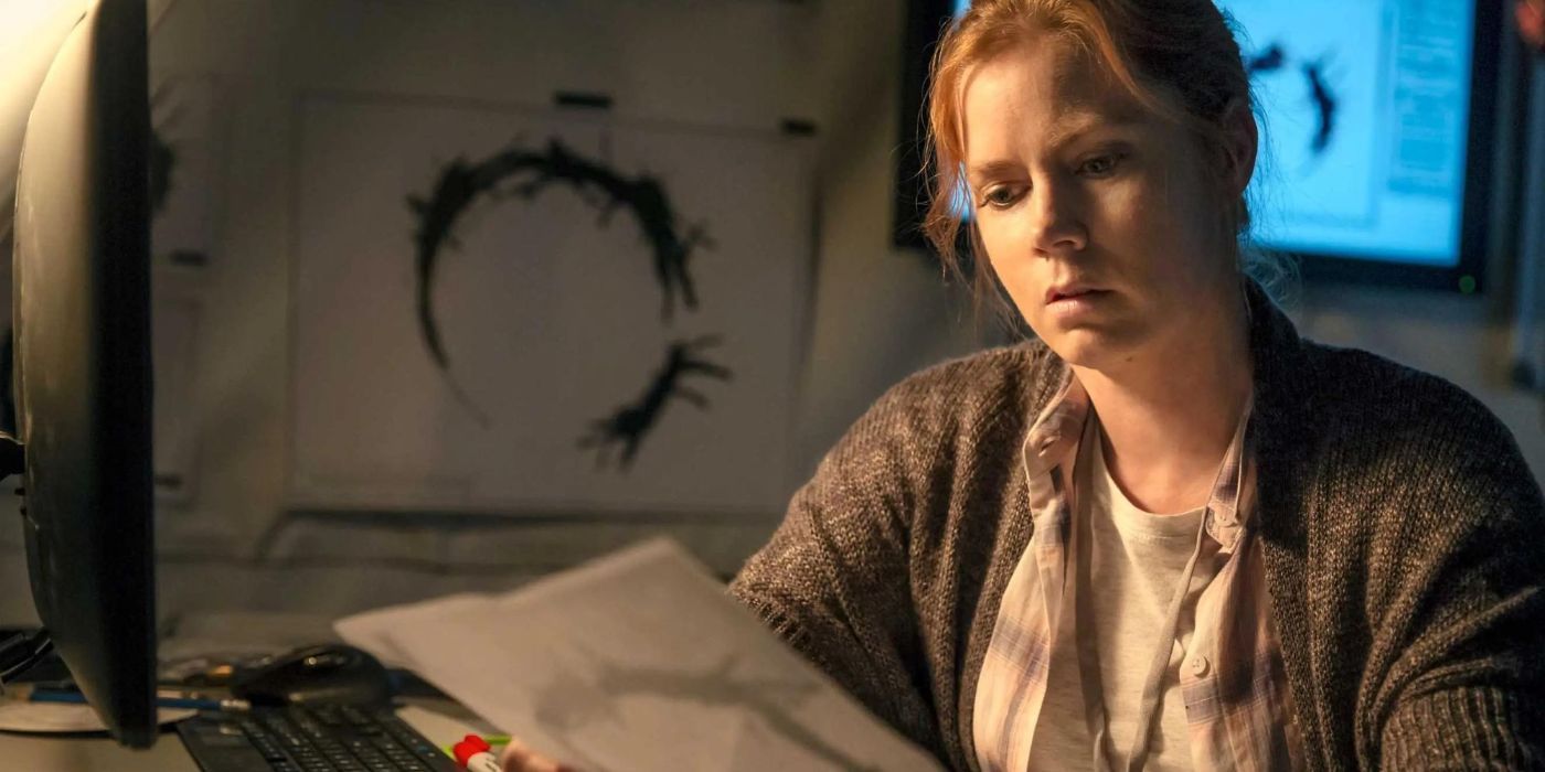 Amy Adams as Louise Banks reading some papers depicting the aliens' circular language in 'Arrival'