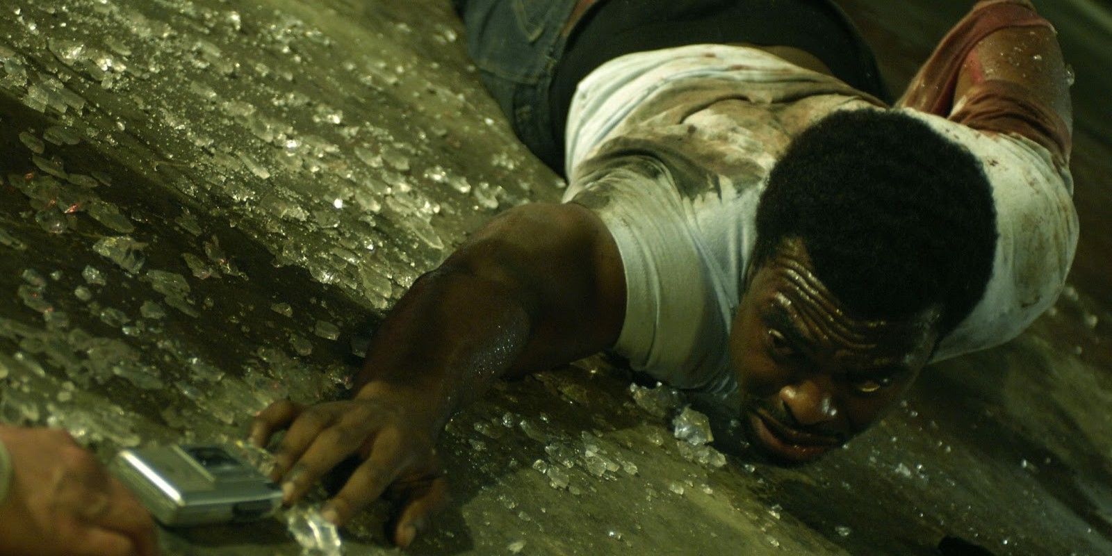 Lyriq Bent crawling along a glass-covered floor towards a phone in Saw IV
