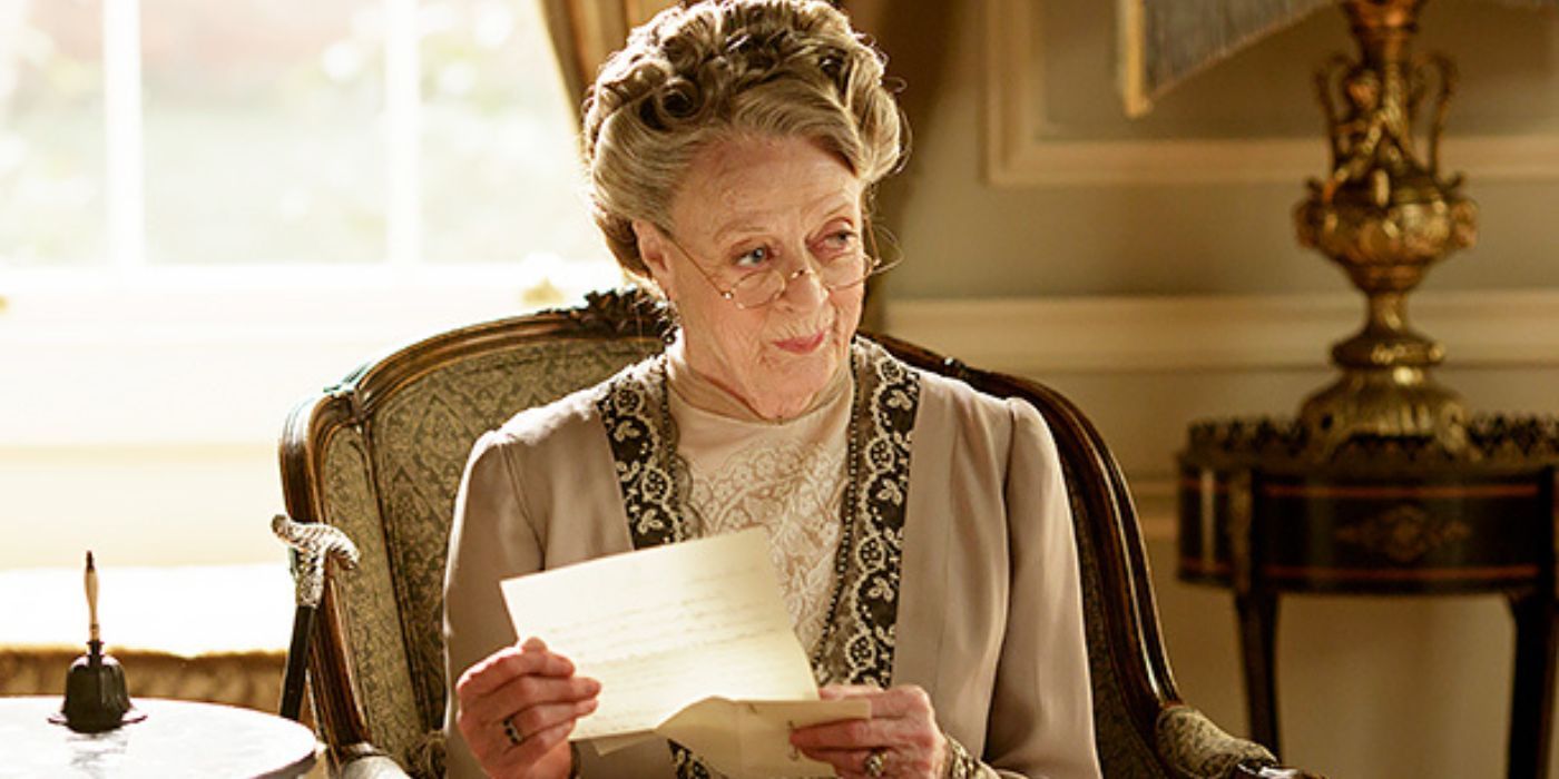 Maggie Smith sitting in a chair reading a letter in Downtown Abbey