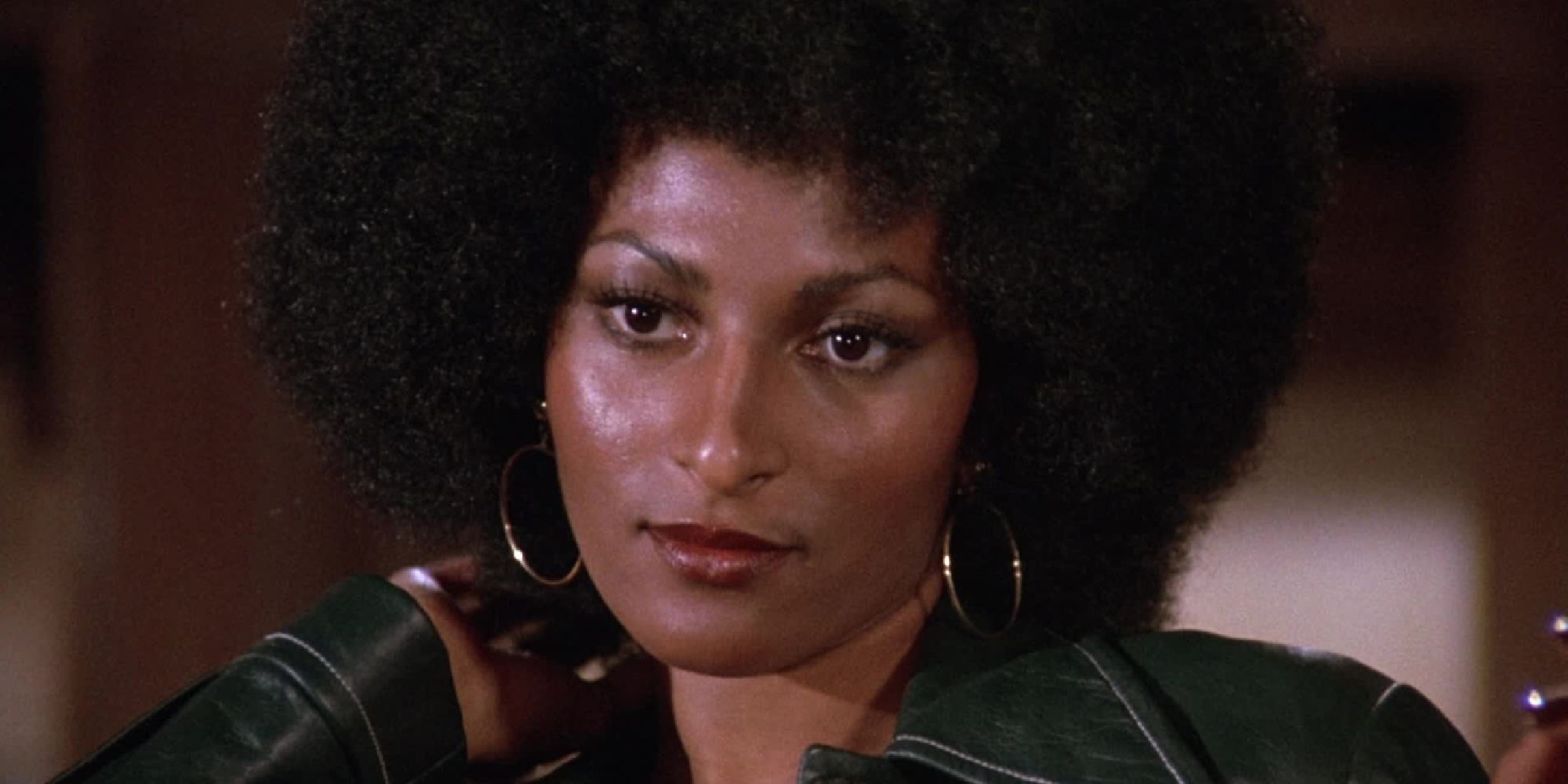 Pam Grier in Foxy Brown looking at someone or something off-camera and smirking.