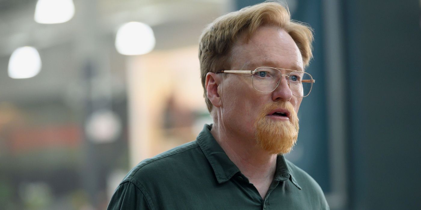 Conan O&rsquo;Brien with a goatee and glasses in a green shirt in Please Don&rsquo;t Destroy: Treasure of Foggy Mountain