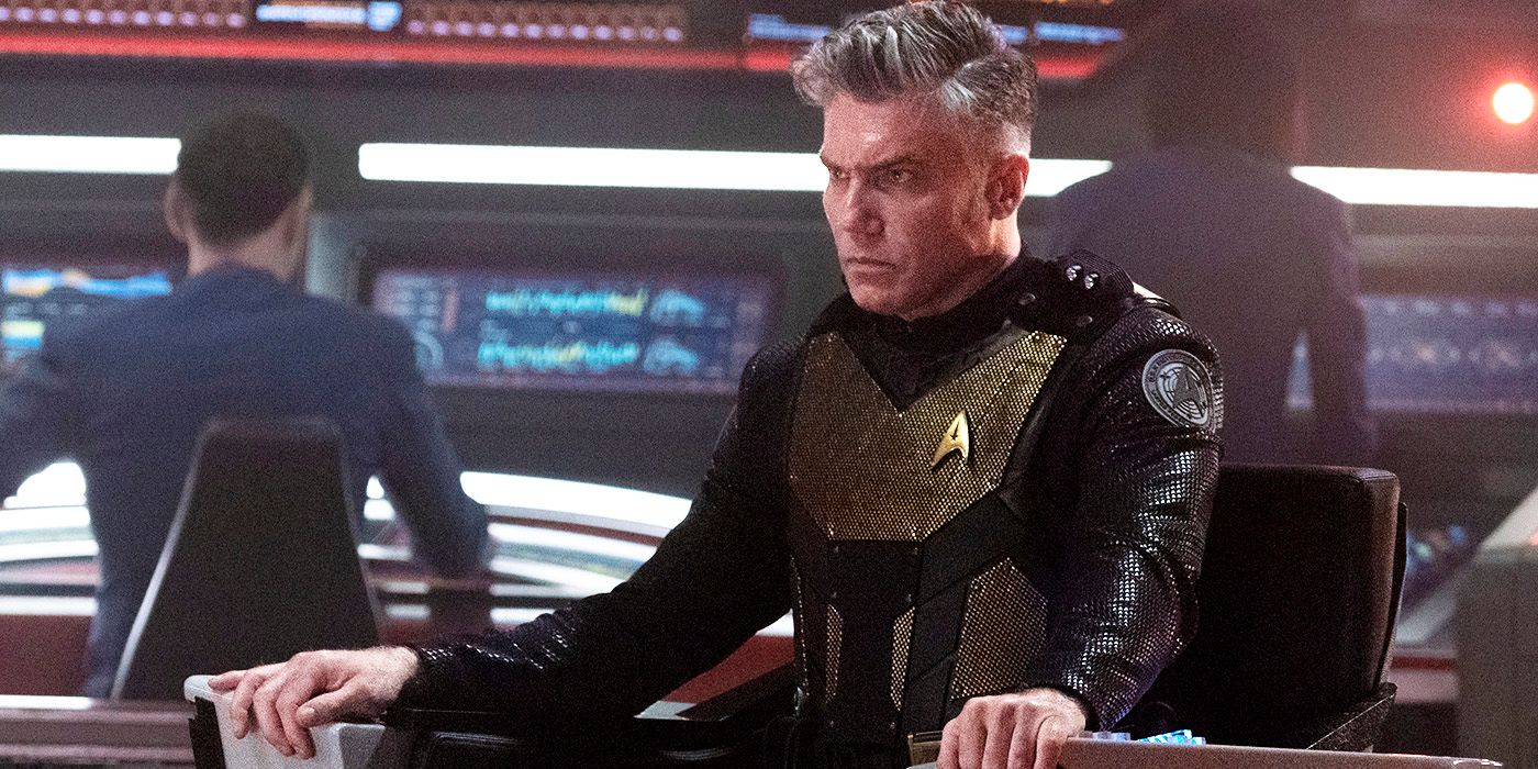 Anson Mount as Captain Pike in tactical gear in the captain's chair on the Enterprise in Star Trek: Strange New Worlds