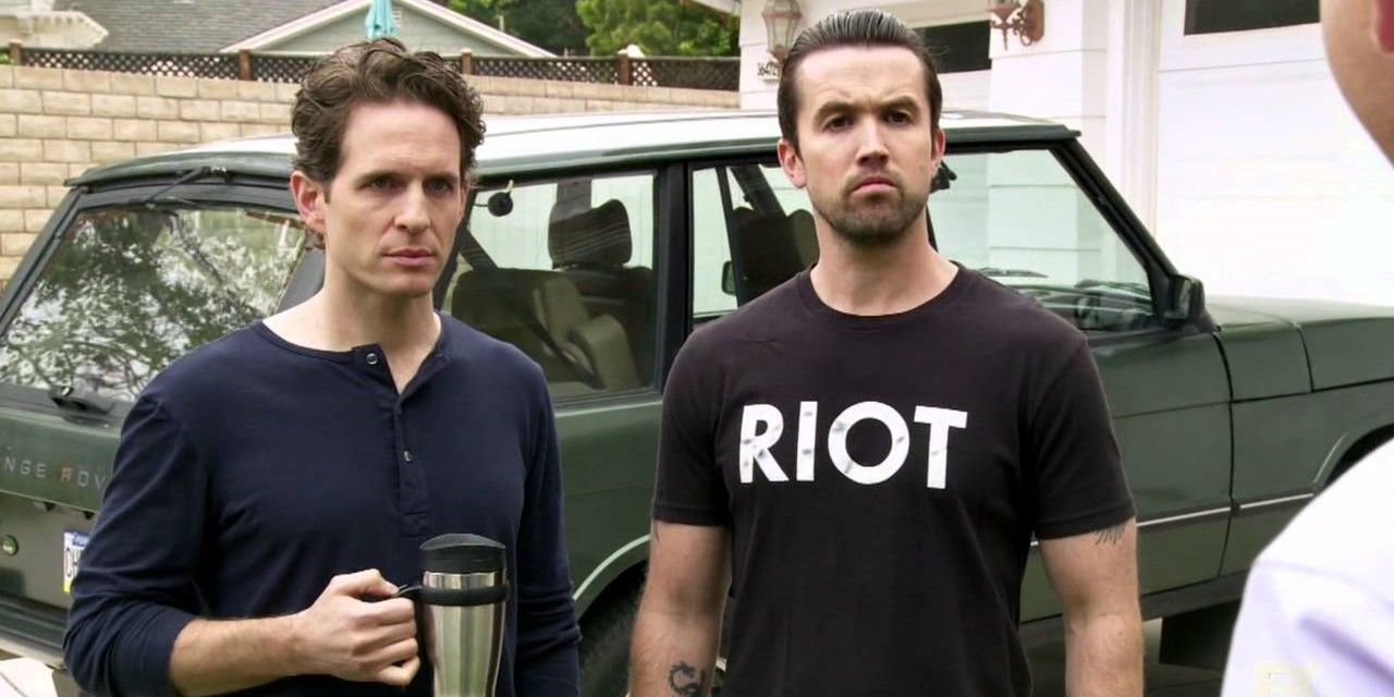 Still from 'It's Always Sunny in Philadelphia': Mac and Dennis stand in front of a car, glaring at a man.